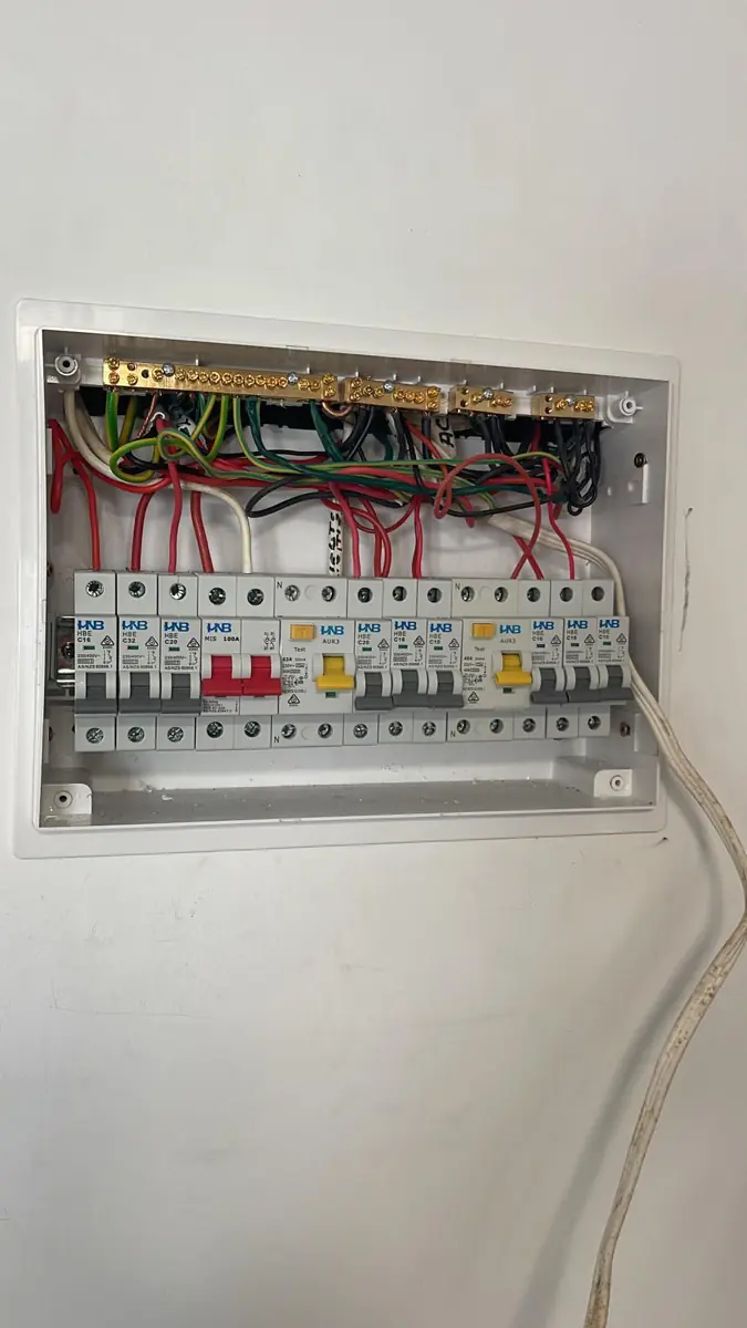 Inside a newly wired consumer unit showing dressed and colour-coded conductors