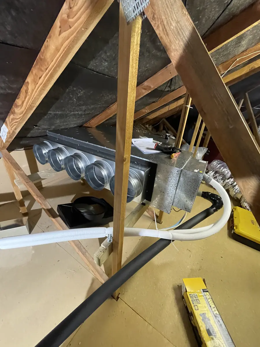 A ducted air conditioning supply plenum with spigots installed in a roof space