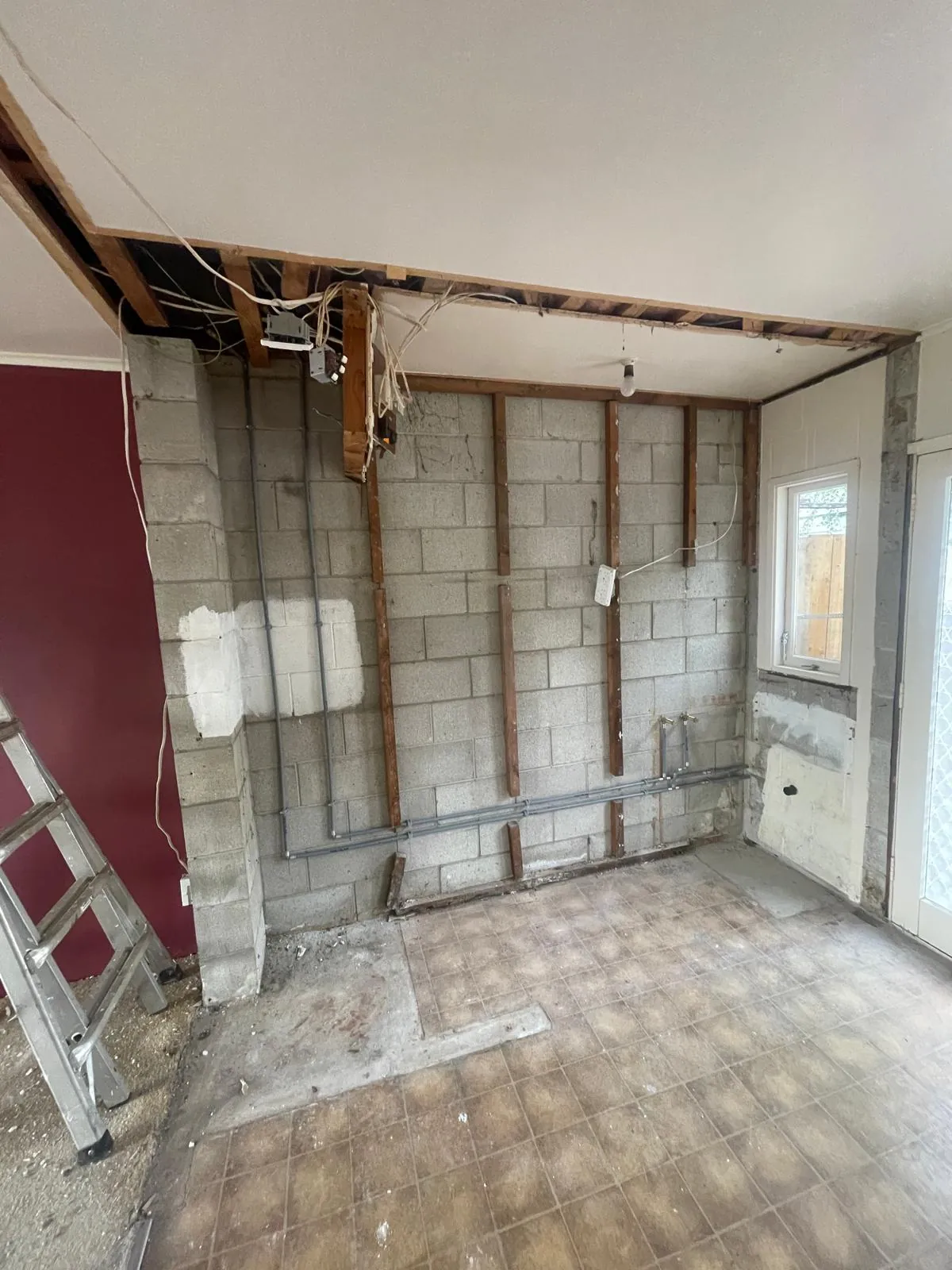 A renovation with the walls opened to blockwork and new conduit run across them