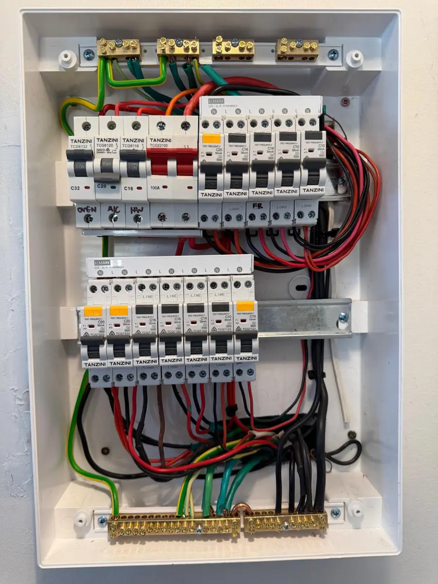 Inside a newly wired consumer unit showing neatly dressed and colour-coded wiring